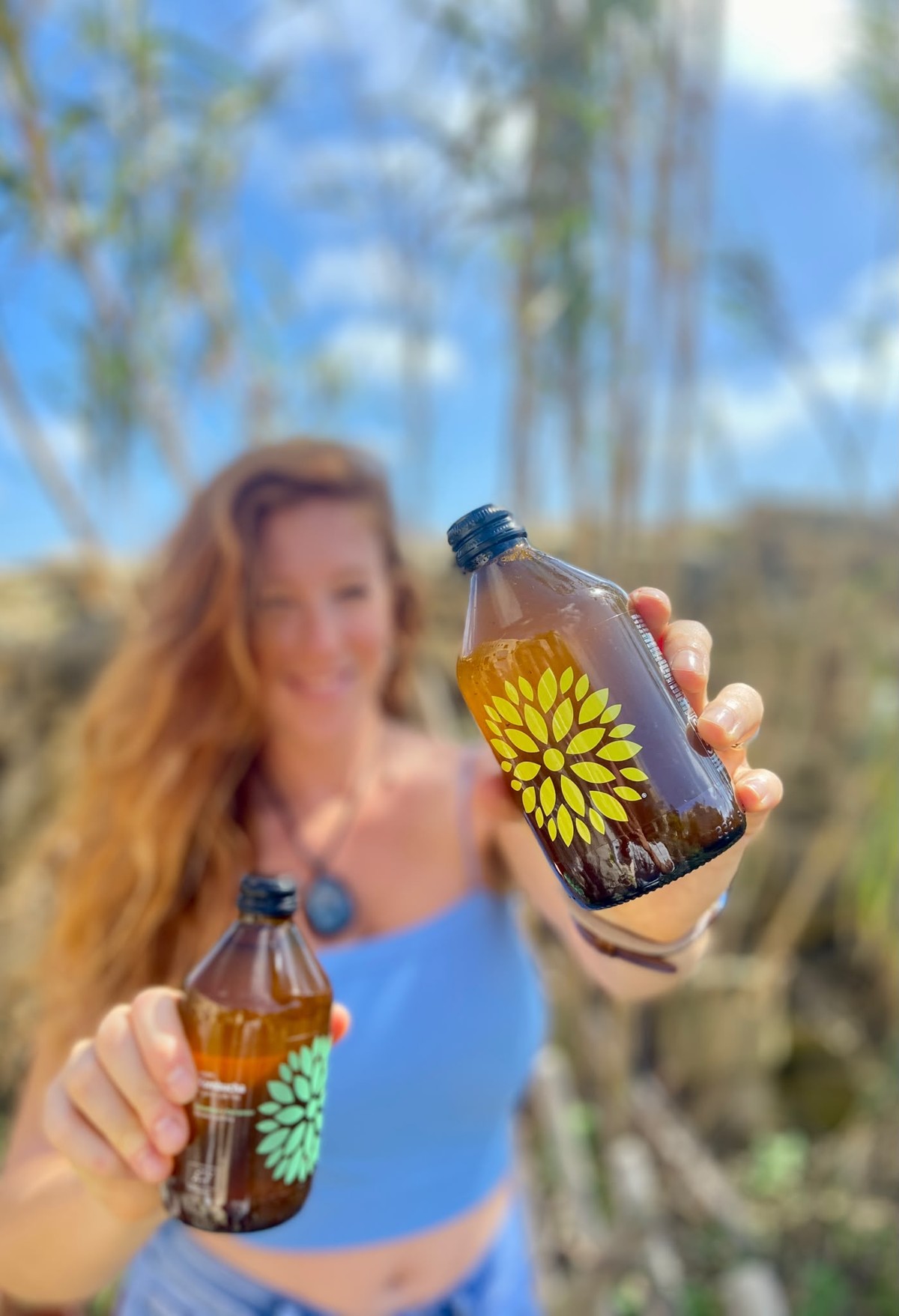 Stefania holding two Now O'Clock kombucha bottles in Gozo